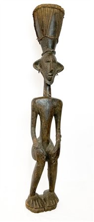 Arte Africana. Scultura virile assisa in legno intagliato, il copricapo decorat
