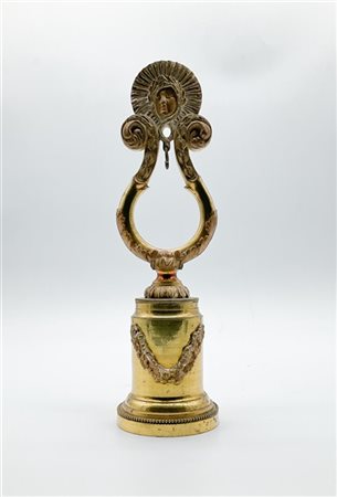 Porta orologio da tasca in bronzo dorato sagomato a lira con cimasa in forma di