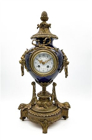 Pendola da appoggio in bronzo dorato con cassa in foggia di vaso in porcellana