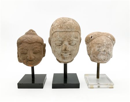 Manifatture diverse. Tre antiche teste in ceramica, su basi moderne (h. max cm