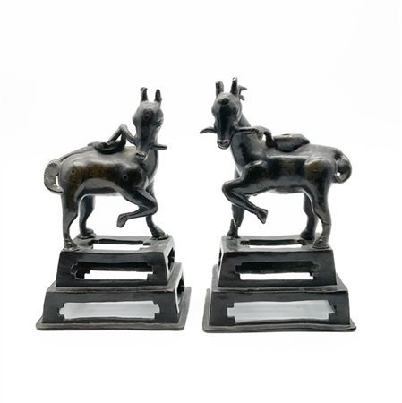 Manifattura orientale. Due antichi candelieri in bronzo a forma di animale su p