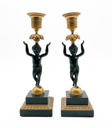 Coppia di candelieri di gusto Impero in bronzo brunito e dorato con fusto a fig