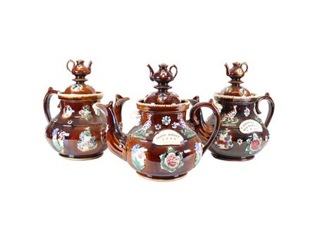 Gruppo di tre teiere in ceramica Bargeware a fondo marrone decorate in rilievo