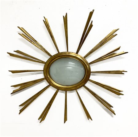 Cornice a raggiera stilizzata in legno dorato, luce ovale con vetro bombato. Se