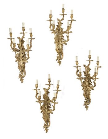 Gruppo di quattro applique a cinque luci in bronzo dorato, sostegno e bracci a