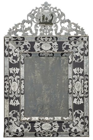 Grande specchiera rivestita in vetri sagomati in parte incisi su fondo in vetro