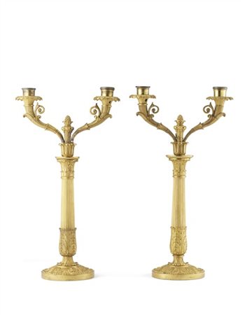 Coppia di candelabri a due luci in bronzo dorato, fusto a colonna scanalata, ba