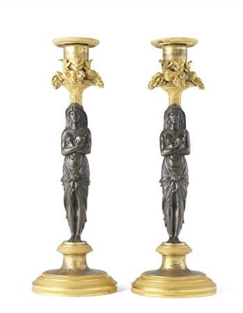 Coppia di candelieri in bronzo dorato, fusto brunito a forma di figura femminil
