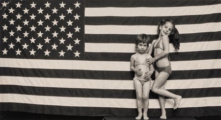 Elliott Erwitt (1928 - 2023)  - Sasha and Emy, in front of American flag, 1983