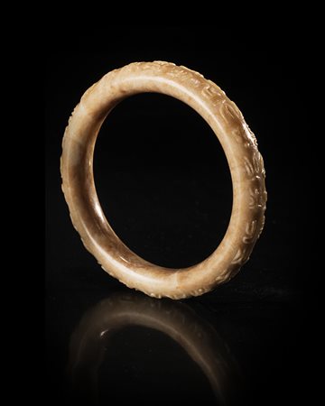 Un bracciale in giada grigia con marezzature scure, decorato con iscrizioni...