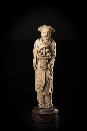 Scultura in avorio raffigurante una fanciulla stante con in mano un cesto di...