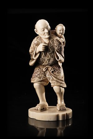 Piccolo okimono in avorio raffigurante un uomo con un fanciullo sulle spalle,...