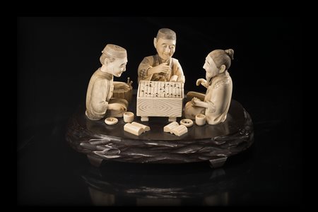 Gruppo in avorio raffigurante tre giocatori di go con tavolo e libri, su base...