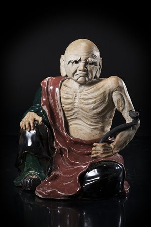 Luohan in ceramica invetriata in marrone, nero e verde, la figura emaciata,...