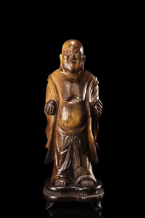 Scultura in pietra dura di Budai stante, con espressione gioviale, con le...