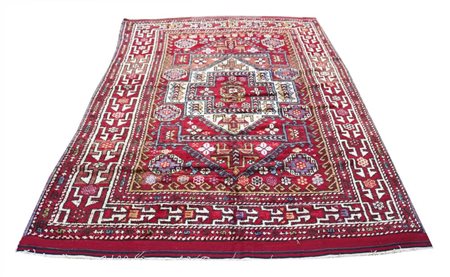 Un grande medaglione, scalettato ed uncinato, domina il fondo color rosso....