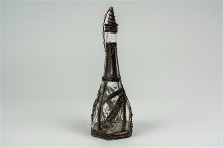 Bottiglia con tappo in vetro incolore a base esagonale montata in metallo argentato lavorato a filigrana. Probabilmente Turchia, secolo XIX