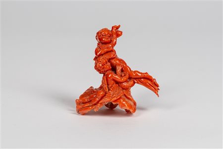 Scultura in corallo scolpito a tutto tondo raffigurante due putti alati su nuvola uno con colomba, l’altro librato in aria con un libro, avvolti da un drappo mosso. Bottega napoletana, secolo XIX