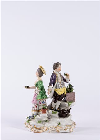 Gruppo in porcellana policroma raffigurante due figure in un giardino, su base a rocaille. Manifattura di Samson, fine secolo XIX/inizio XX.