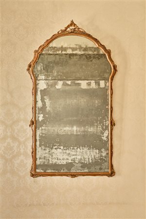 Specchiera di forma mossa con cornice in legno intagliato e laccato a motivi floreali, cimasa traforata e cuspidata. Venezia, secolo XVIII