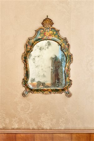 Specchiera di forma mossa in legno intagliato e laccato a volute e fiori. Venezia, secolo XVIII