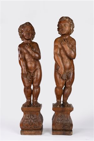 Coppia di putti in legno intagliato su basi a plinto. Fine secolo XVII