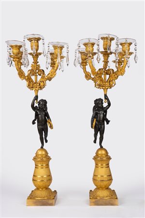Coppia di candelabri in bronzo brunito e dorato con sostegno a putto. Francia, secolo XIX