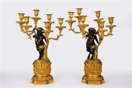 Coppia di candelabri a sei luci in bronzo dorato e patinato con fusto a fauno. Da un modello di Clodion, Francia, inizio secolo XX
