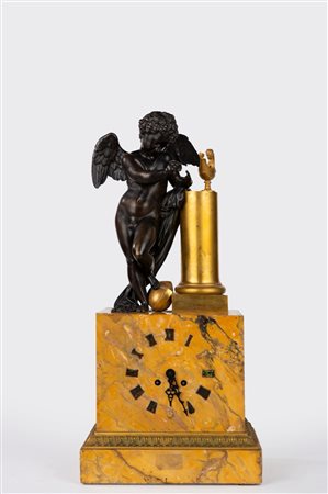Orologio da appoggio in marmo giallo di Siena, bronzo dorato e patinato sormontato da Cupido. Francia, secolo XIX 