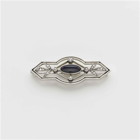 Spilla in oro bianco con diamanti ed al centro una pasta vitrea blu ovale...