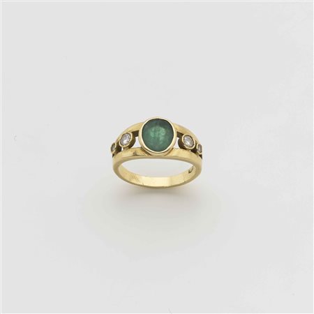 Anello in oro giallo con quattro diamanti rotondi e al centro uno smeraldo...