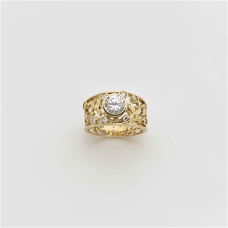 Anello a fascia in oro giallo con piccoli diamanti ed al centro un diamante...