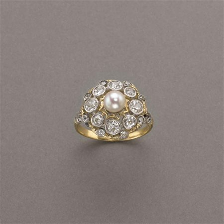 Anello in oro giallo e argento a forma tonda con al centro una perla...