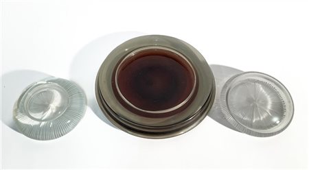 Lotto di un posacenere in vetro sommerso e due fermacarte in vetro. Italia, ann