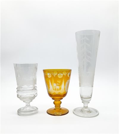 Manifattura di Boemia, secolo XX. Tre calici in vetro incolore e ambrato inciso