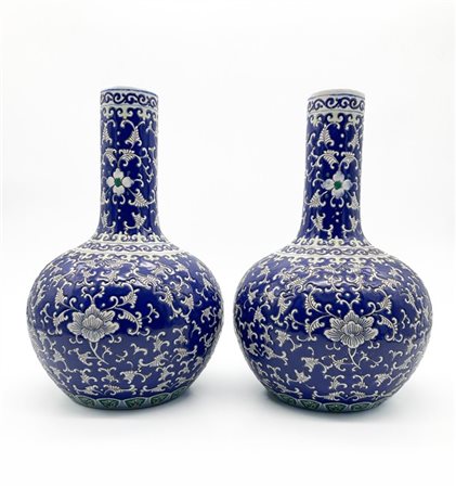 Coppia di vasi a bottiglia in porcellana dipinta nei toni del blu con decoro fl