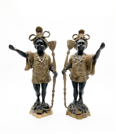 Coppia di figure di moretti in metallo brunito e dorato reggenti portacandela (