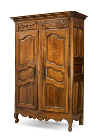 Armadio in noce a due ante con pannellature sagomate, parte superiore con fasci