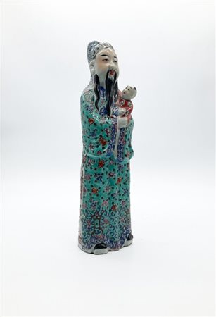 Figura di dignitario cinese con bambino in porcellana dipinta in policromia. 
C