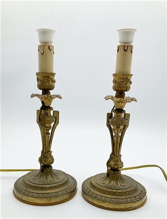 Coppia di candelieri in bronzo dorato con base circolare decorata a palmette e