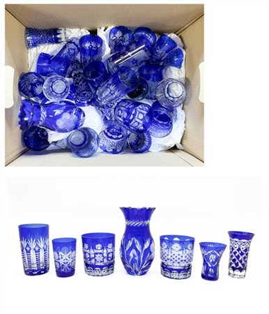 Cartone contente numerosi bicchieri in vetro e cristallo blu e incolore decorat