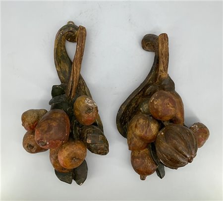 Coppia di fregi in legno intagliato e dipinto in policromia a frutti e pigne. S