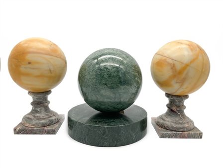 Lotto composto da tre sfere in marmi vari delle quali una coppia con base quadr