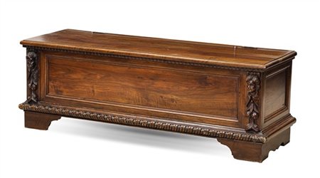 Cassapanca in legni vari con fronte riquadrato e montanti intagliati a teste d'