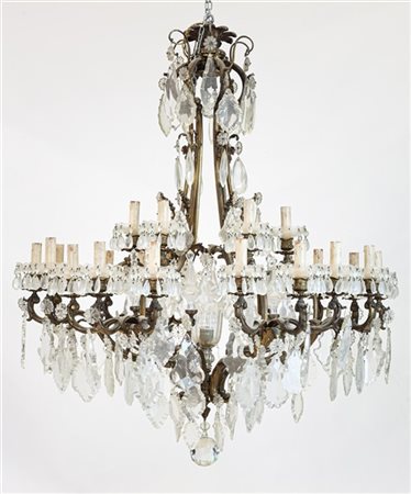 Lampadario a ventuno luci in bronzo dorato con bracci a volute, pendenti e pinn