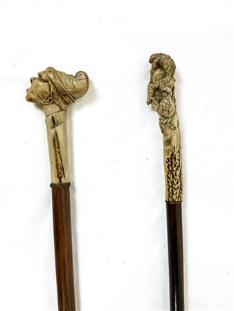 Due bastoni da passeggio con canna in legno e presa in corno scolpito a testa c