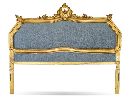 Testiera da letto in legno intagliato e dorato con cimasa traforata a volute e