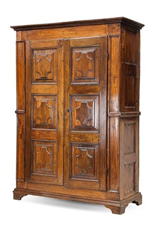 Armadio in noce a due ante pannellate con riquadrature a rilievo, piedi a menso