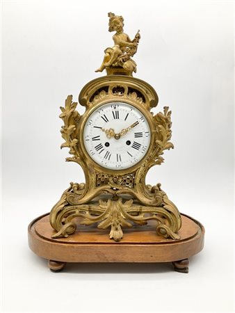 Pendola da appoggio in bronzo dorato con cassa riccamente decorata a motivi roc