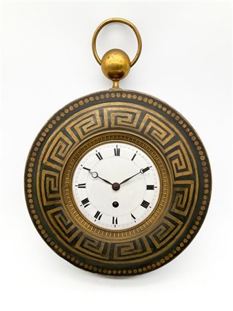 Orologio da parete in lamiera laccata a greche con presa ad anello. Quadrante i